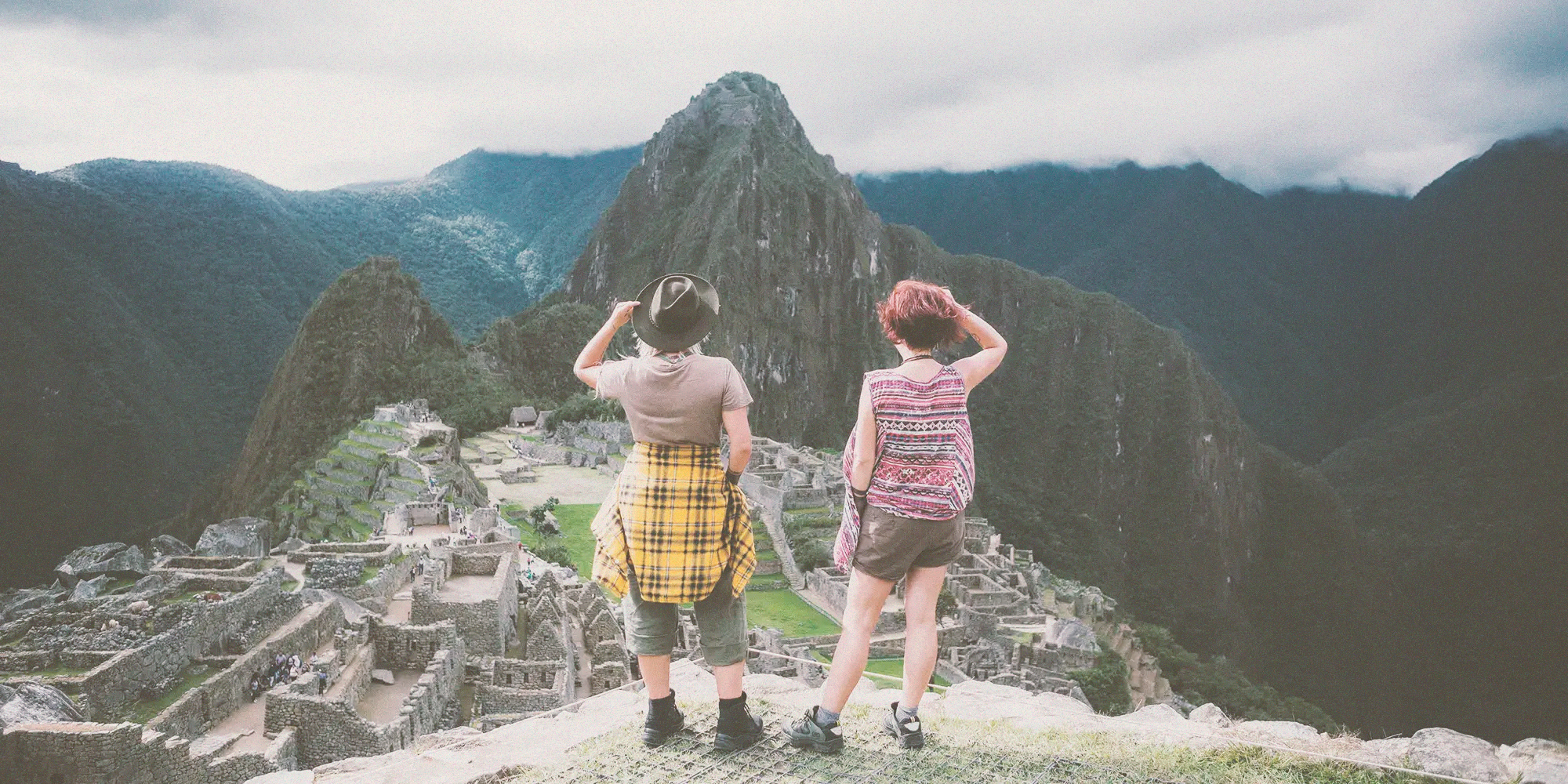 Three travelers looking out over an Andean valley from a mountain trail